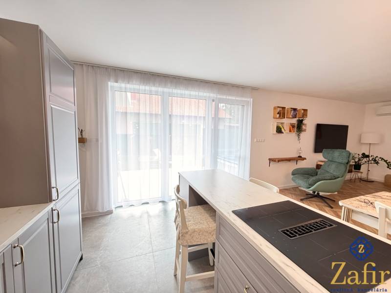 Kitchen and living room in a family house with modern furniture and large windows.
