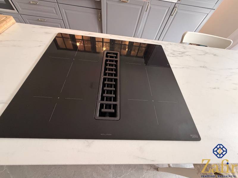 Induction cooktop in the kitchen with a marble countertop in a family house.