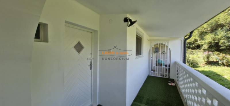 The entrance area of a 2-room apartment in Hollóháza with white doors and a green carpet.