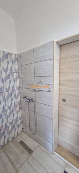 Bathroom in a 2-room apartment with modern tiles and a shower corner.