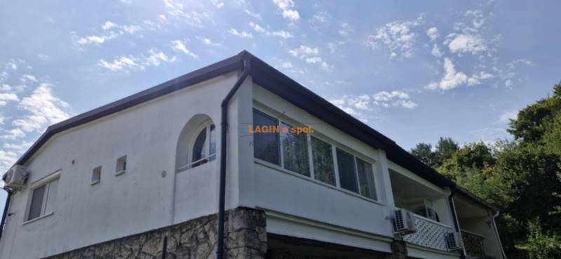 A view of the exterior of a 2-room apartment in Hollóháza with a stone foundation.