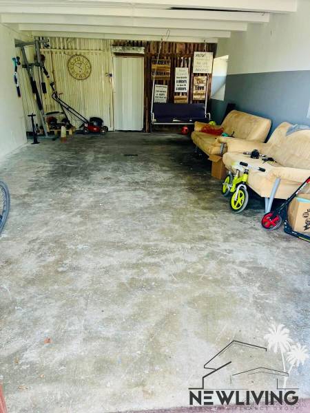 A garage in a 3-room apartment with tools and a couch, suitable for storage.