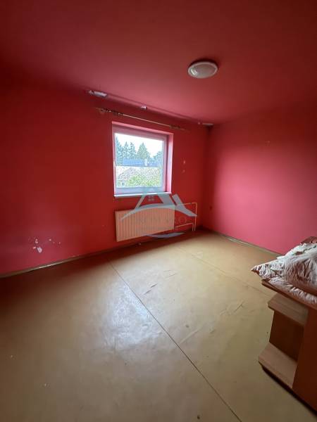 A room in a family house with red walls and simple furniture.