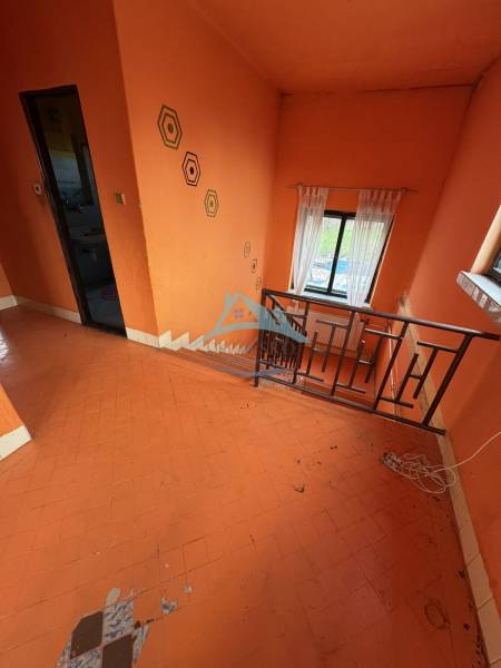 Orange walls and staircase in a family house with geometric patterns and a window.