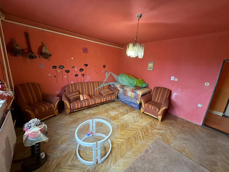 Living room in a family house with red walls and counter furniture.