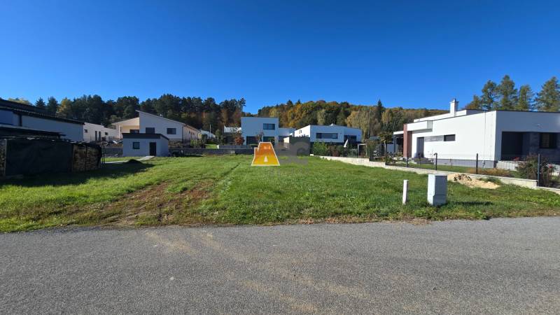 Plots - housing in Kováčová with family houses in the background and green grass.