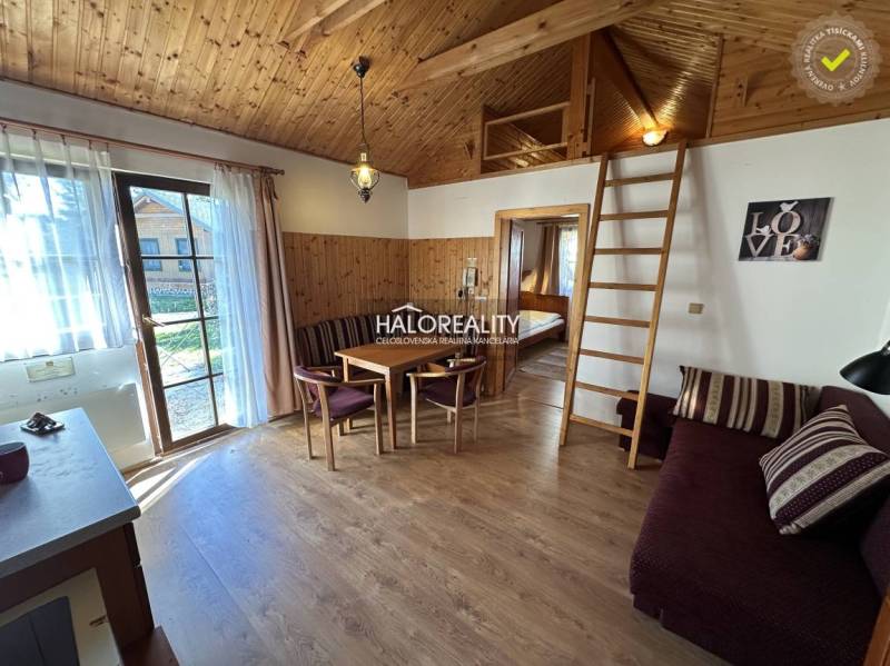 A bedroom with three beds, a wooden ceiling, a floor with a wood decor, and a cabinet.