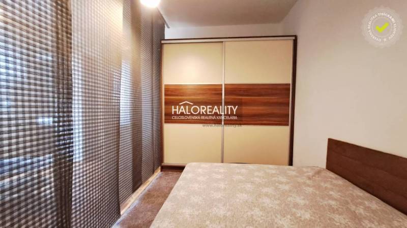 A bedroom in a one-room apartment with a large wardrobe and a bed.