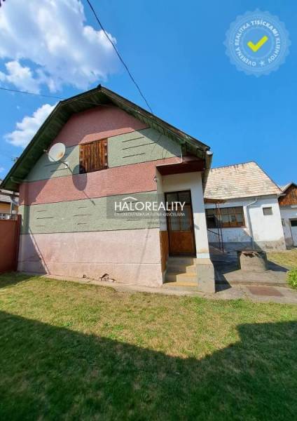 A family house in Zvolen with a colorful facade, a satellite dish, and a grassy yard.