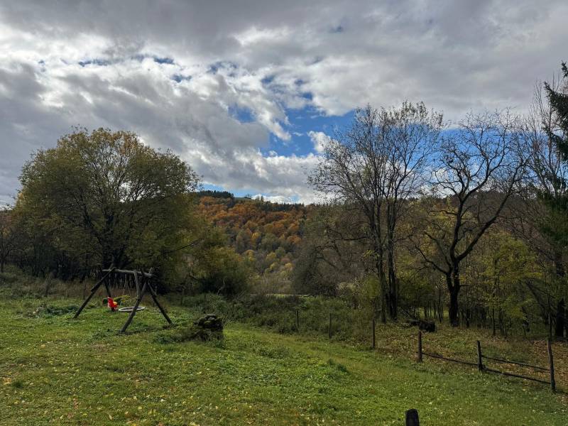 Autumn landscape from the cabin in Píla with a swing on the green meadow.