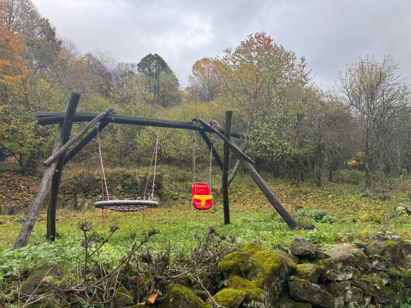 Swings by the cottage in the village of Píla, surrounded by nature and autumn leaves.