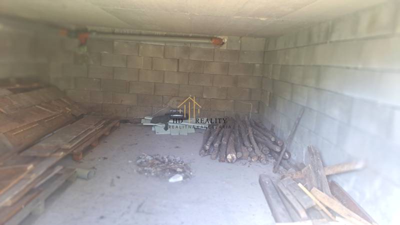 A wood storage in a family house in Hokovce with brick walls and a concrete floor.