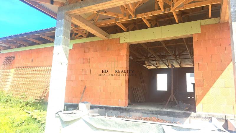 An unfinished family house in Hokovce with a brick construction and wooden beams on the roof.