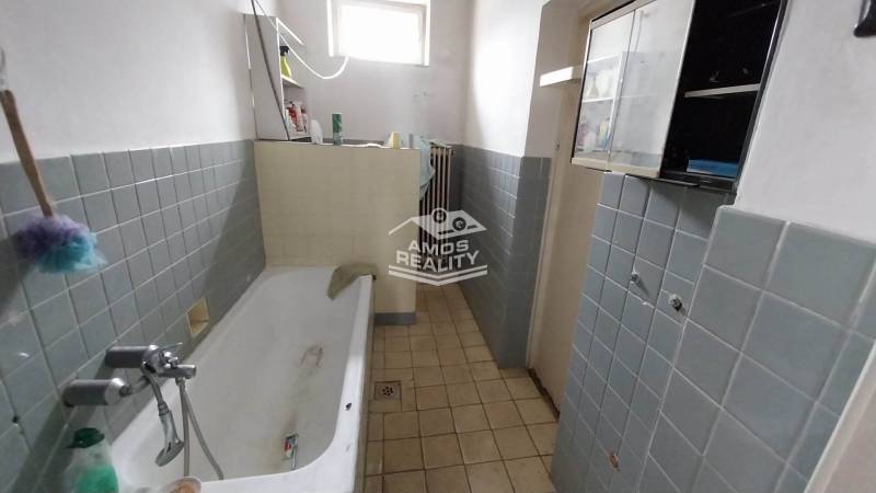 A bathroom with old fixtures and gray-blue tiles in a family house on Štúrova Street.
