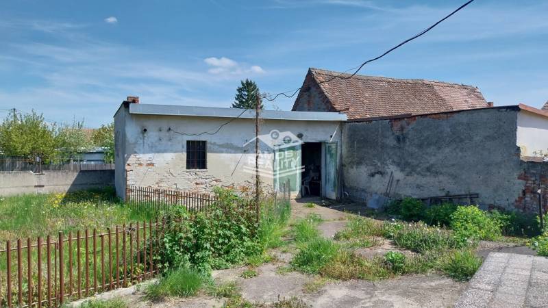 A yard with abandoned buildings and an old fence on Štúrova Street, suitable for a family house.