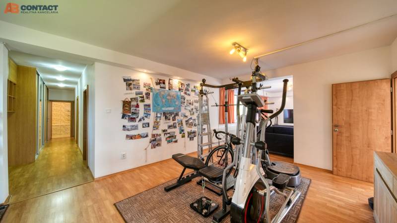 A gym in a family house with a wooden decor floor and postcards on the wall.