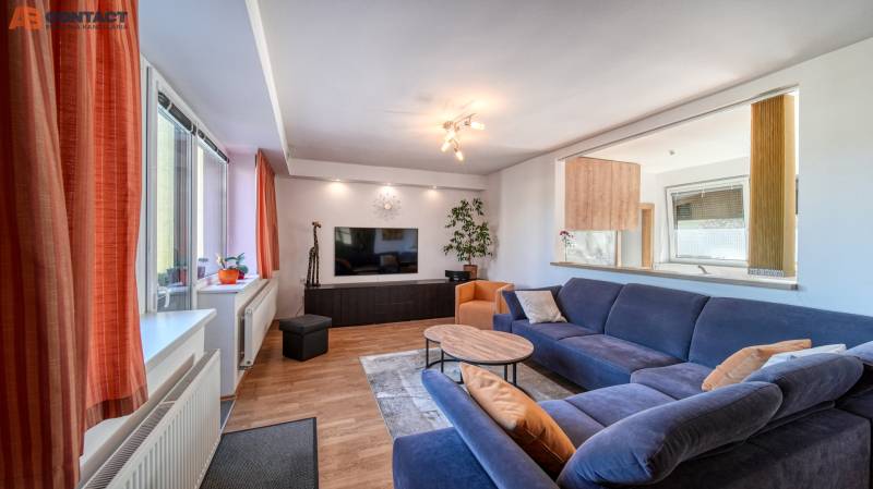 Living room with a dark blue sofa and a wooden decor floor in a family house.