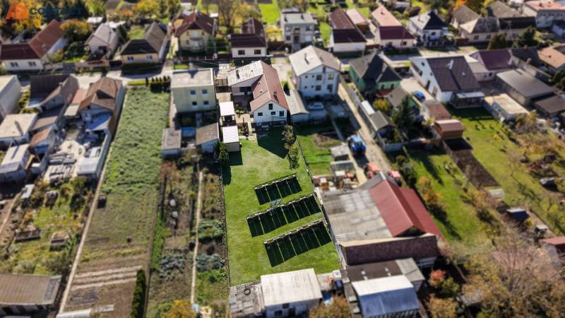 A top-down view of family houses on Južná Street in Veľké Orvište with gardens.