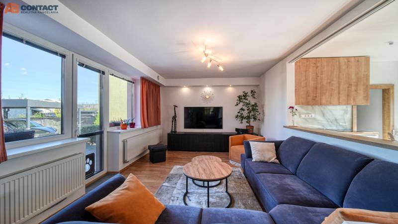 Living room in a family house, comfortable sofa, table and television, floor with wooden decor.