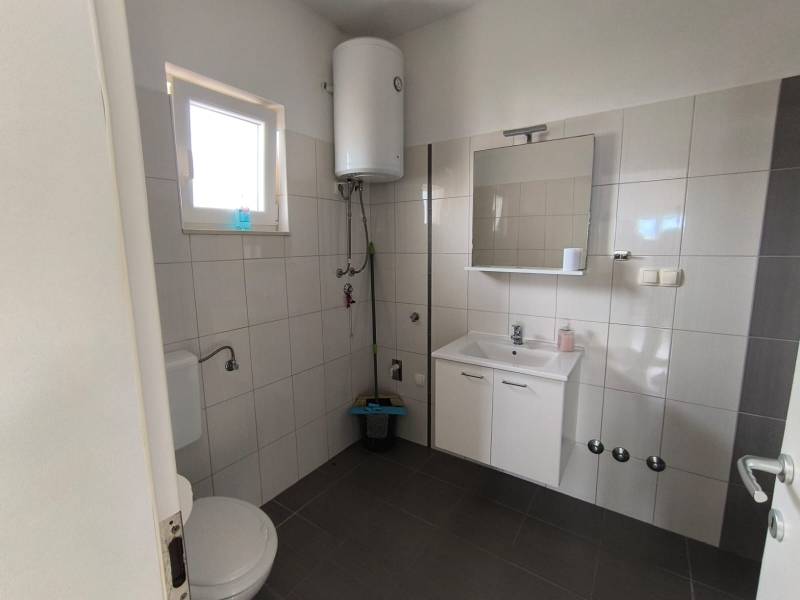 Bathroom in a 3-room apartment with white tiles and sanitary ware.