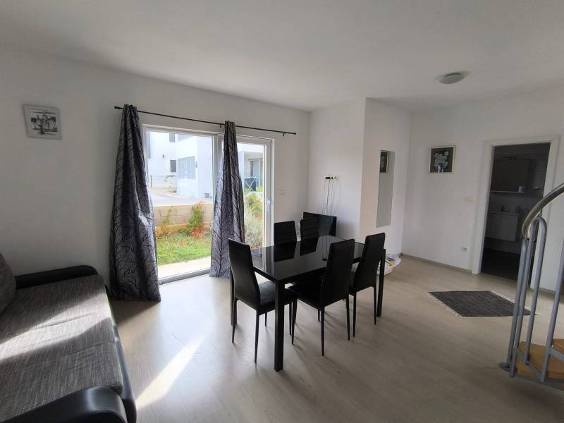 Living room with a black dining table and a wooden decor floor in a 3-room apartment.