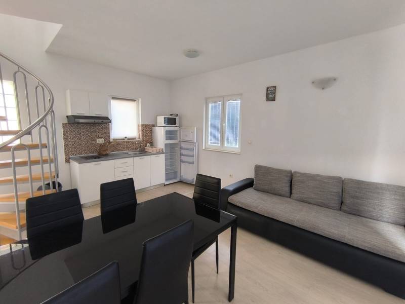 A kitchen in a 3-room apartment with a wooden decor floor, spiral staircase.