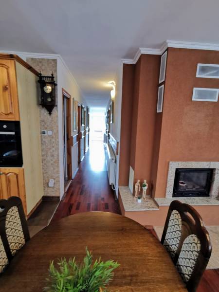 Interior of a family house with a dining room, fireplace, and wooden decor flooring.