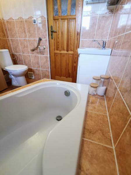 Bathroom in a family house with a shower bath and toilet with tiling.