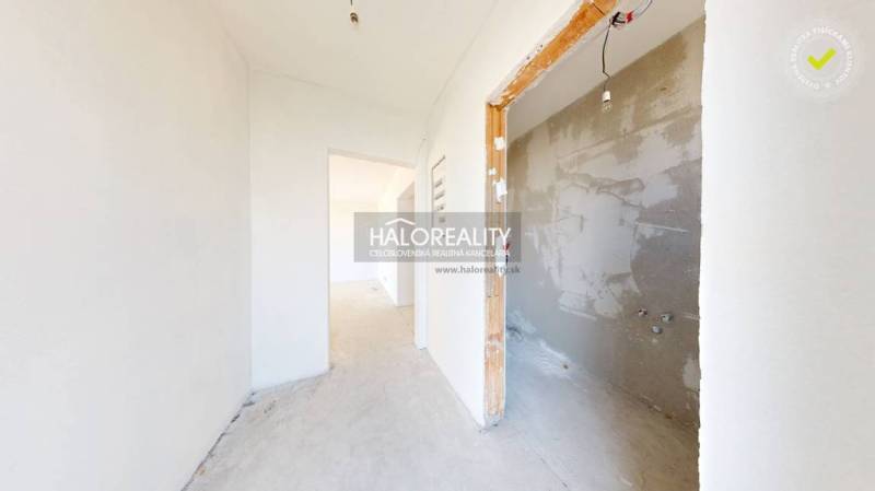A hallway in a family house with unpainted walls and a room ready for renovation.