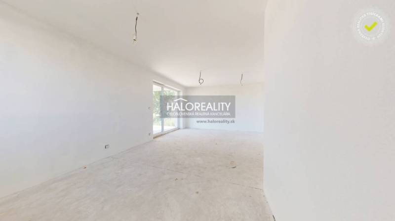 A spacious room with large windows in a family house, waiting to be finished.