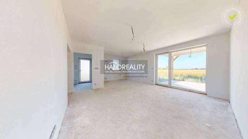 A spacious room with large windows and a view of the garden in a family house.