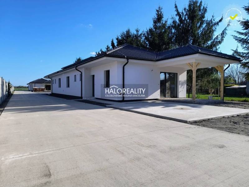 A family house in Blahová with a light facade and a wide adjacent concrete walkway.