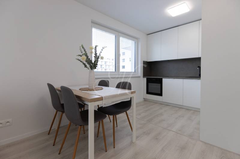 A kitchen with a dining table in a 2-room apartment, floor with wooden decor.