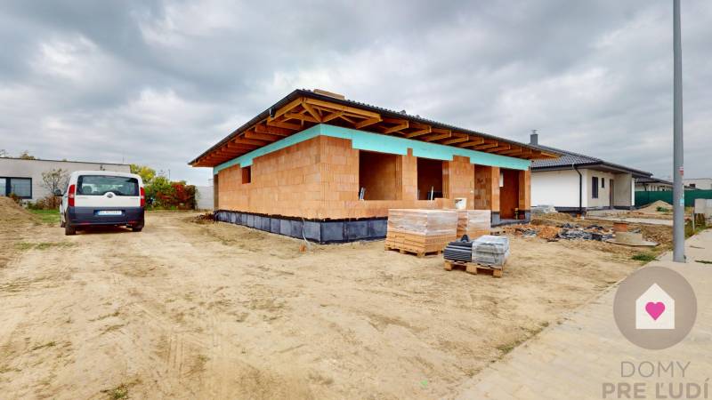 Construction site of a family house in Bernolákovo with an unfinished roof and building materials.