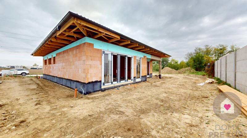 A family house in Bernolákovo in the construction phase with a roof structure made of wooden beams.