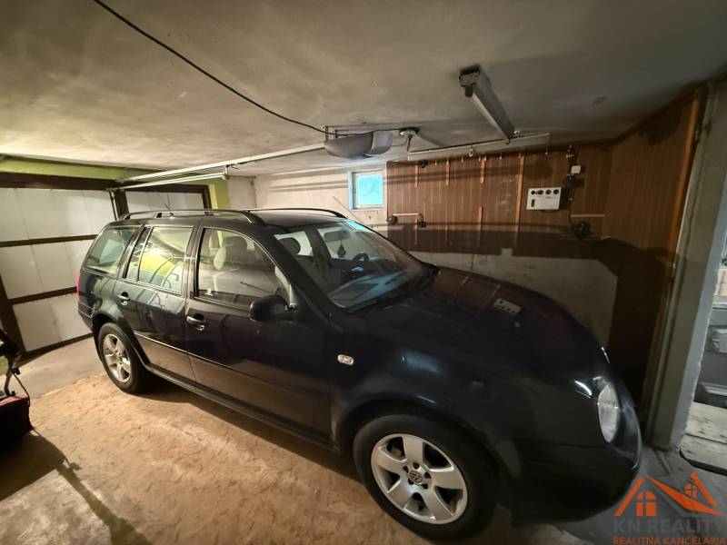 A car parked in a garage in a family house. Floor with wooden decor.