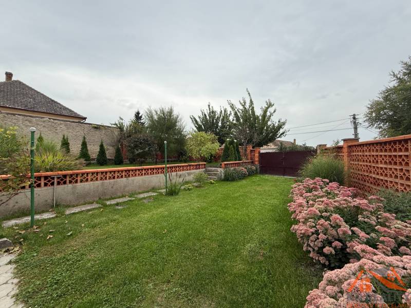 A garden in a family house on Jilemnického Street in Dvory nad Žitavou with flowers and a lawn.
