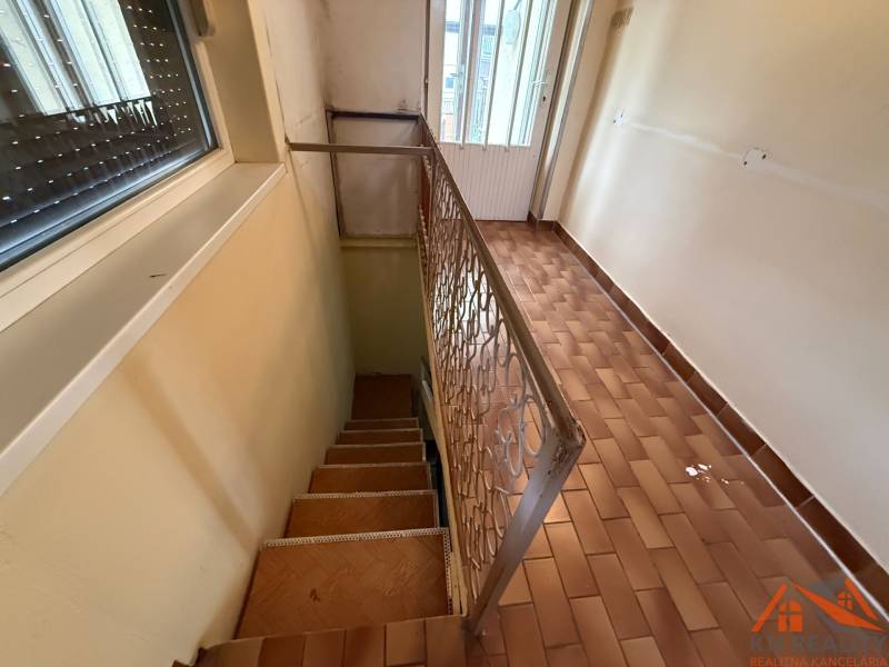 Hallway with ceramic flooring and staircase in a family house.