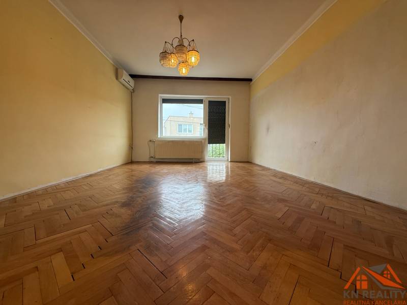 Living room in a family house with a wooden decor floor and a chandelier.