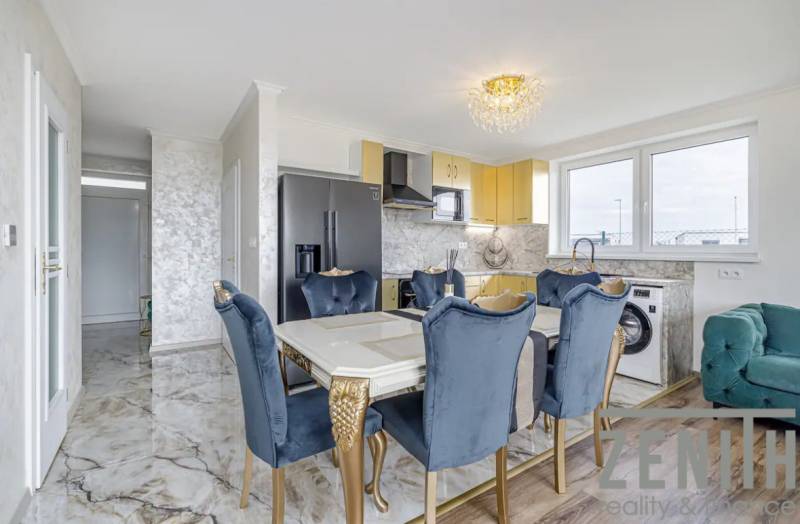 Dining room in a family house with a marble floor, blue chairs, and a gold table.