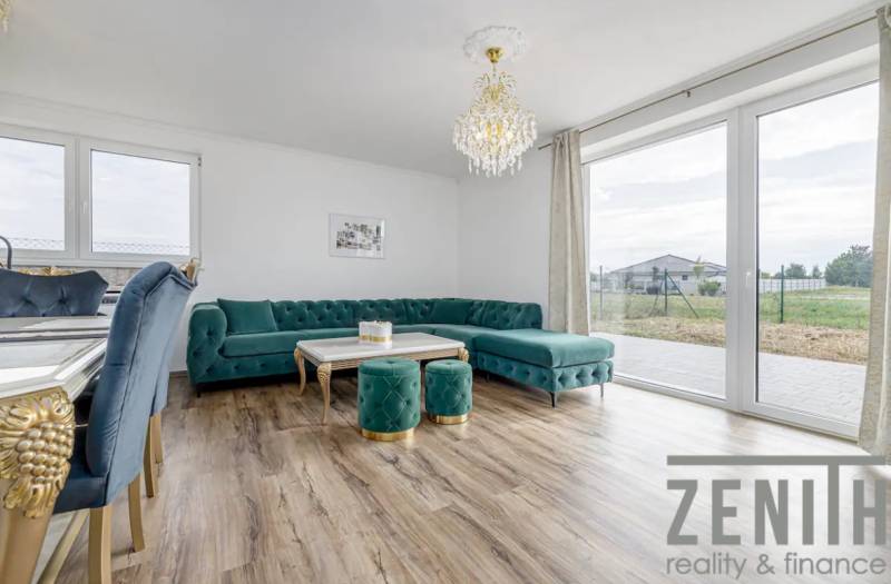 Living room in a family house with a turquoise sofa and a floor with a wooden decor.
