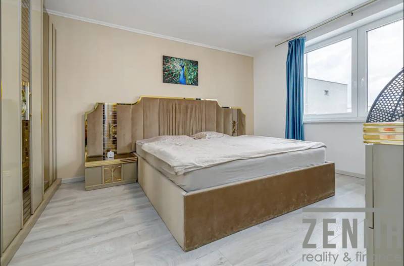 A room with a bed, beige tones and a painting, a floor with a wooden decor.