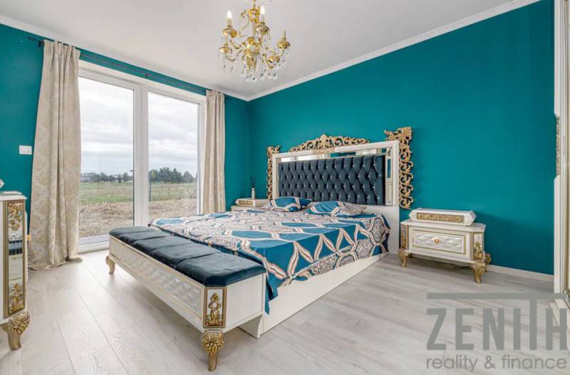 Luxurious bedroom with ornamental furniture, chandelier, and large window in a family house.