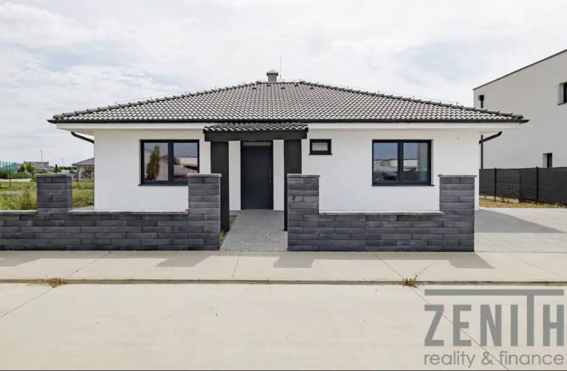 A family house in Hrubá Borša with a gray roof, modern facade, and front garden.