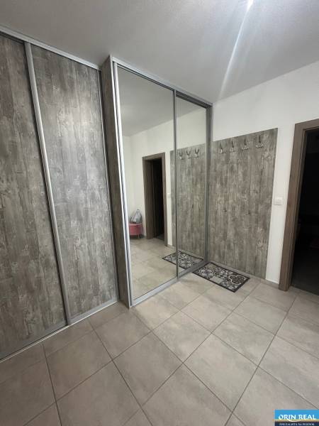 Hallway of a 2-room apartment with a large mirrored wardrobe and wall hooks.