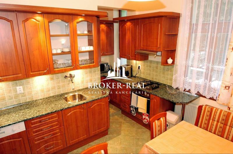 A kitchen with wooden cabinets and a marble countertop, Hotels and guesthouses.