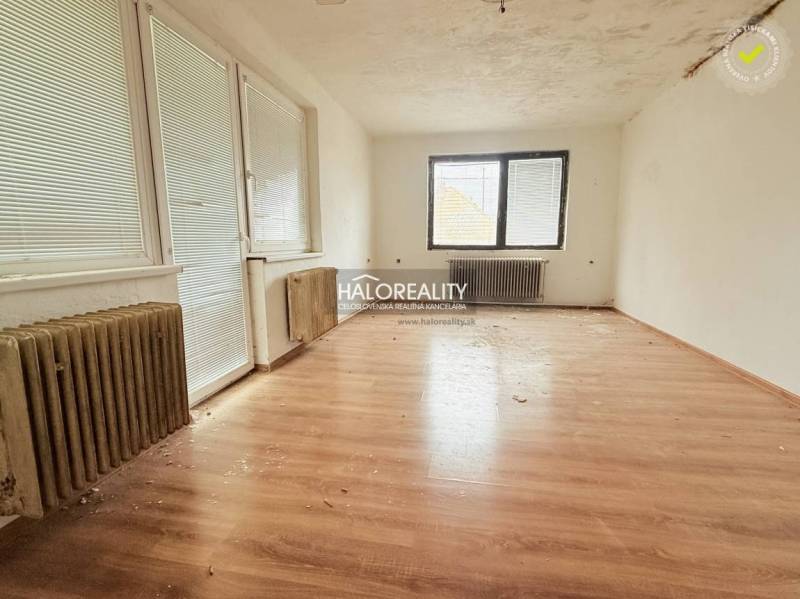 A room in a family house with a wooden decor floor and radiators.