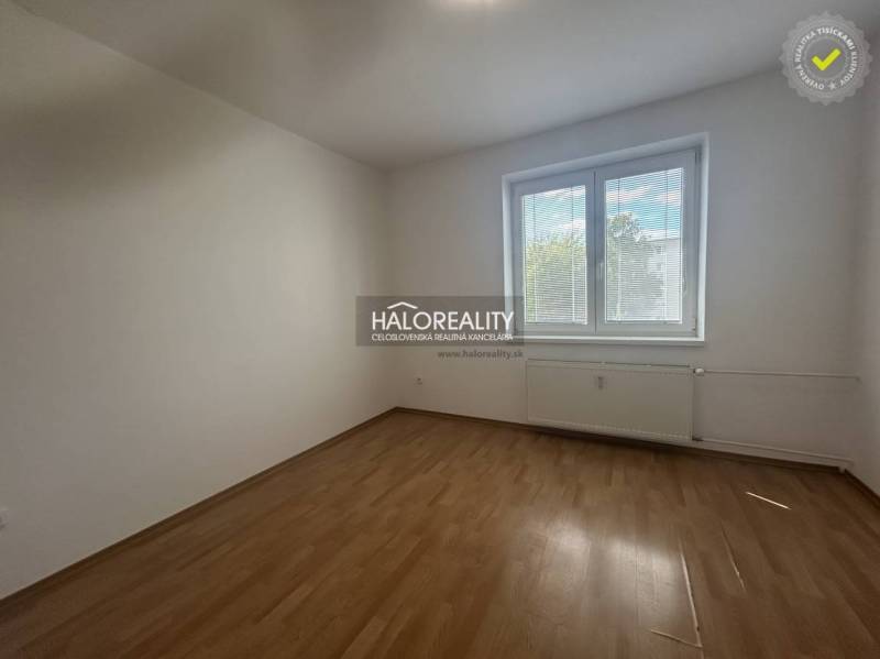 A room in a 3-room apartment with a wooden decor floor and a large window.