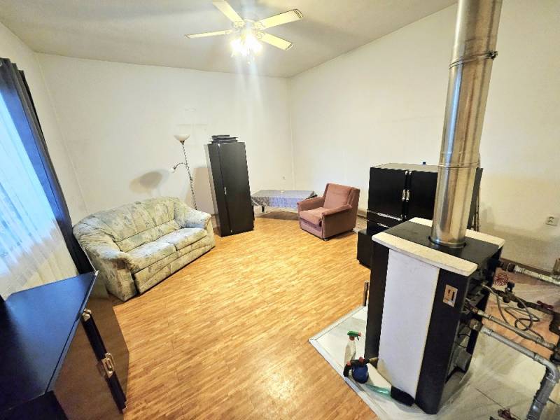 Living room in a family house with a wooden decor floor, sofa, and fireplace.