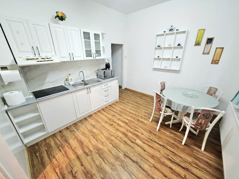 Kitchen in a family house with white cabinets and wood-patterned flooring.